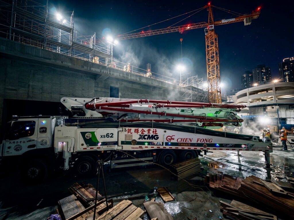 正豐機械 XCMG XS62 混凝土泵浦車於工地夜間灌漿施工，後方為塔式起重機與作業人員